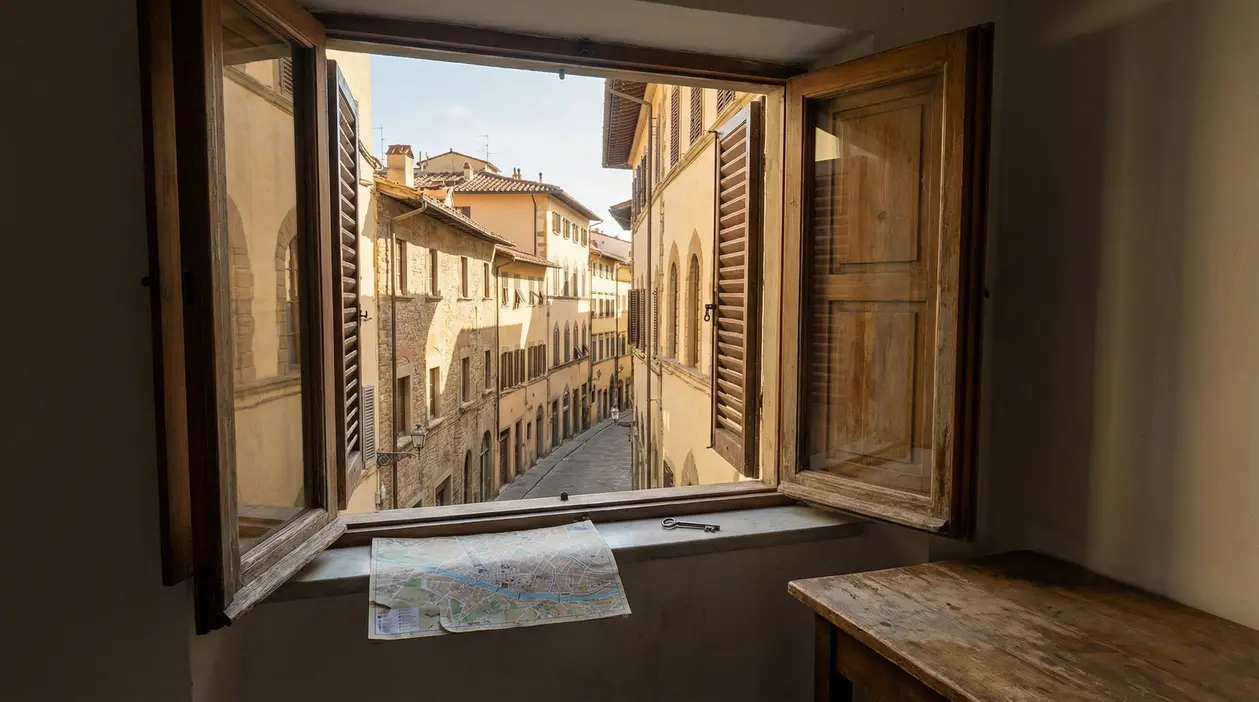 Vista su una strada tranquilla di Firenze da una finestra aperta con mappa sul davanzale