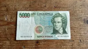 Banconota italiana da 5.000 lire su tavolo in legno